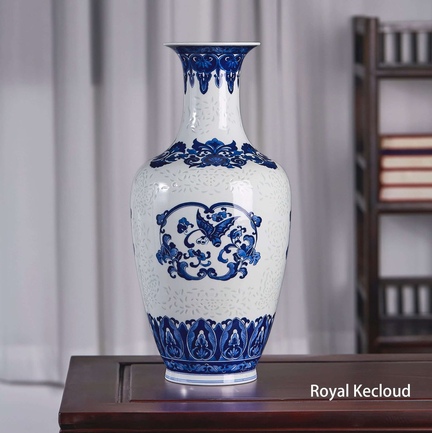 Blue and White Ceramic Vase featuring elegant butterflies and flowers motif on display.